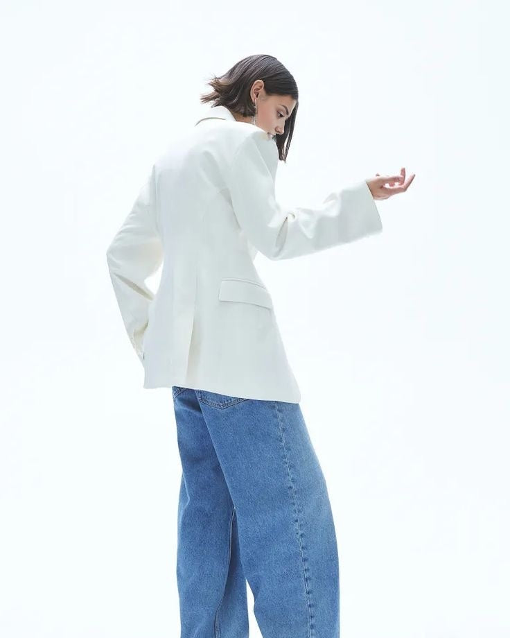 Women's white blazer with padded shoulders and a tailored fit.