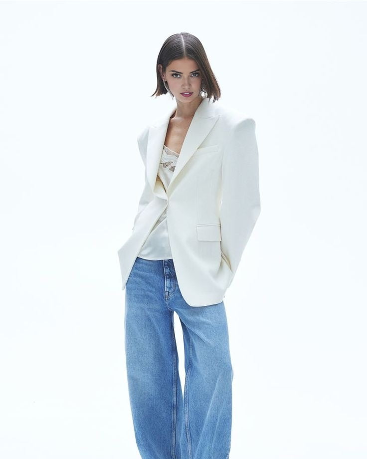 Women's white blazer with padded shoulders and a tailored fit.