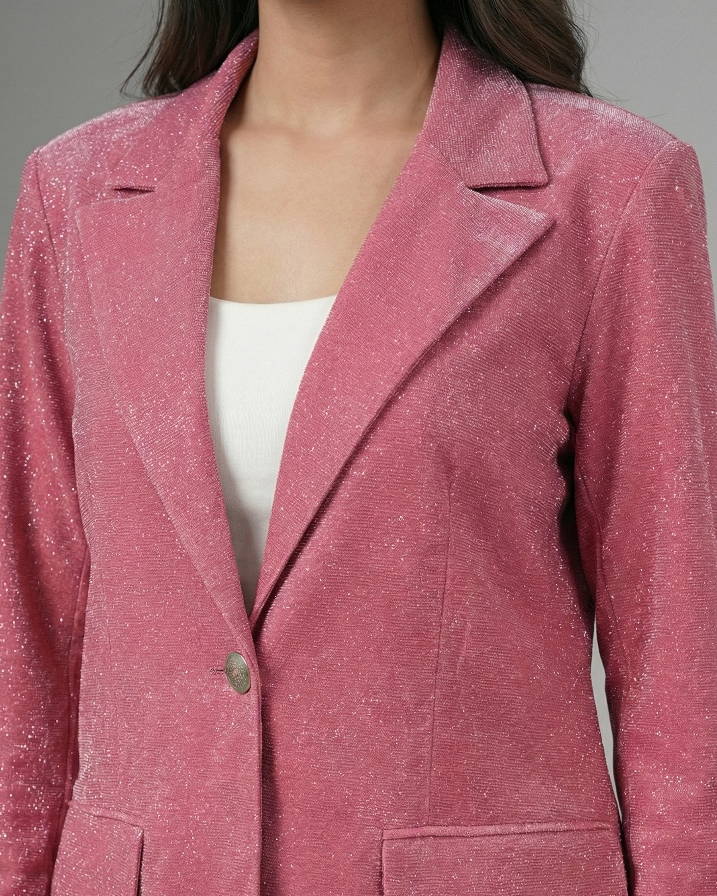 Pink blazer worn by a person on a gray background