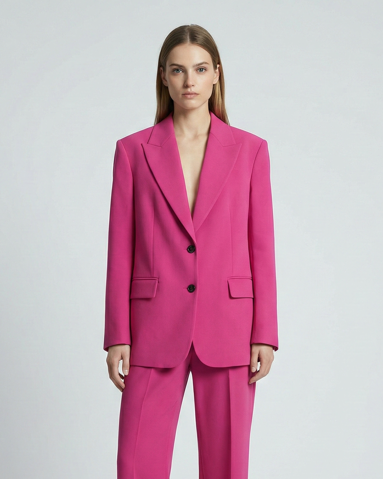 Woman wearing a bright pink suit on a white background
