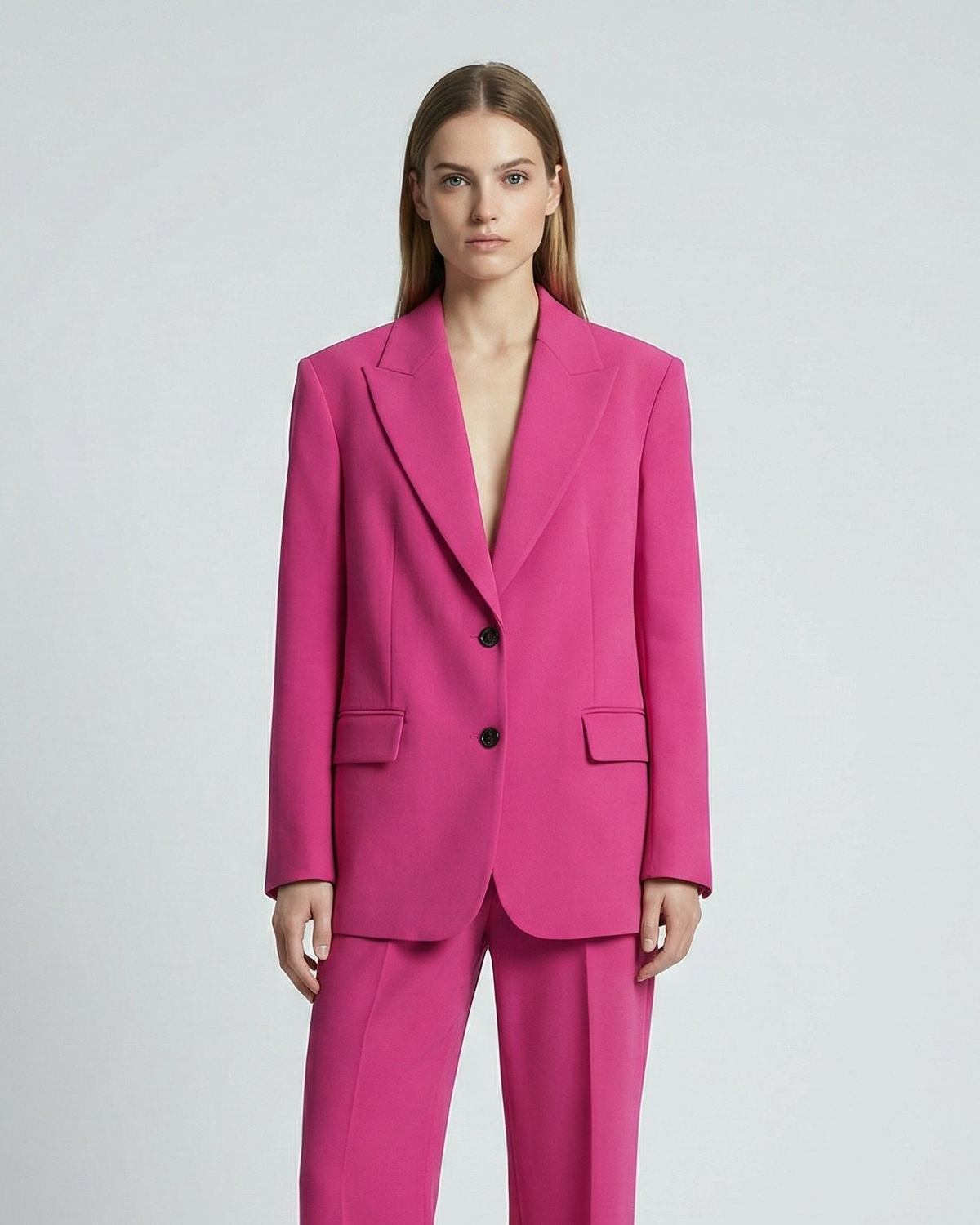 Woman wearing a bright pink suit on a white background