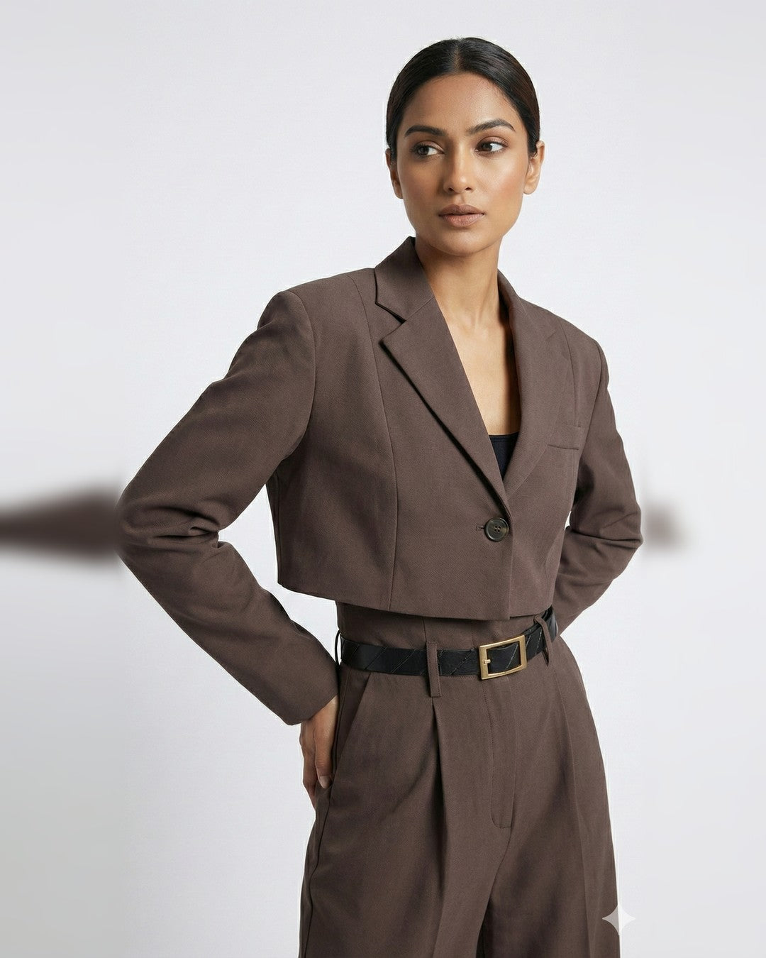 Brown cropped single-button blazer with notch lapels and belted high-waisted trousers on model, close-up | Beyond Formals