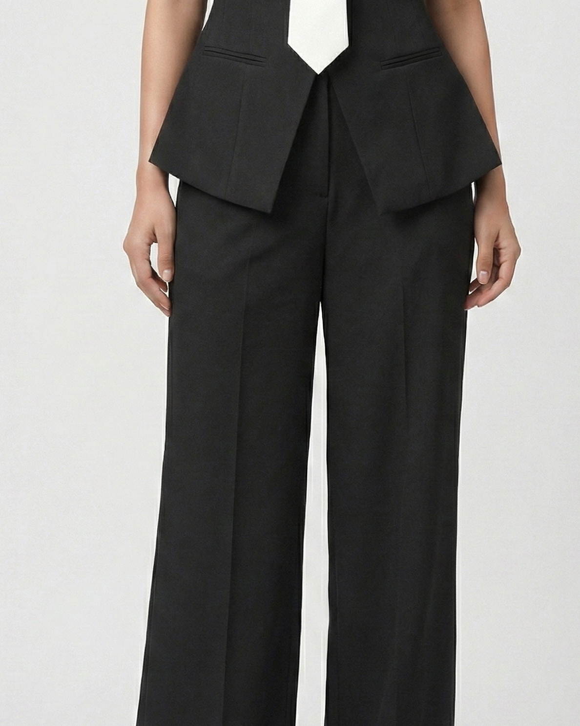 Black suit with a peplum top and wide-leg pants on a white background