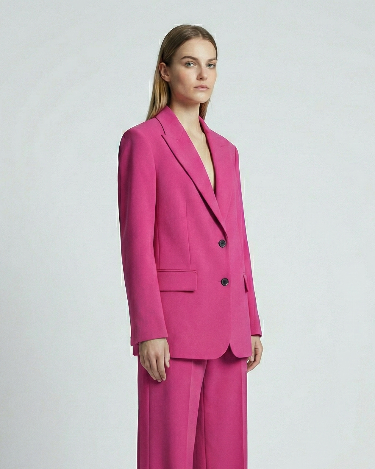 Woman wearing a bright pink suit on a white background