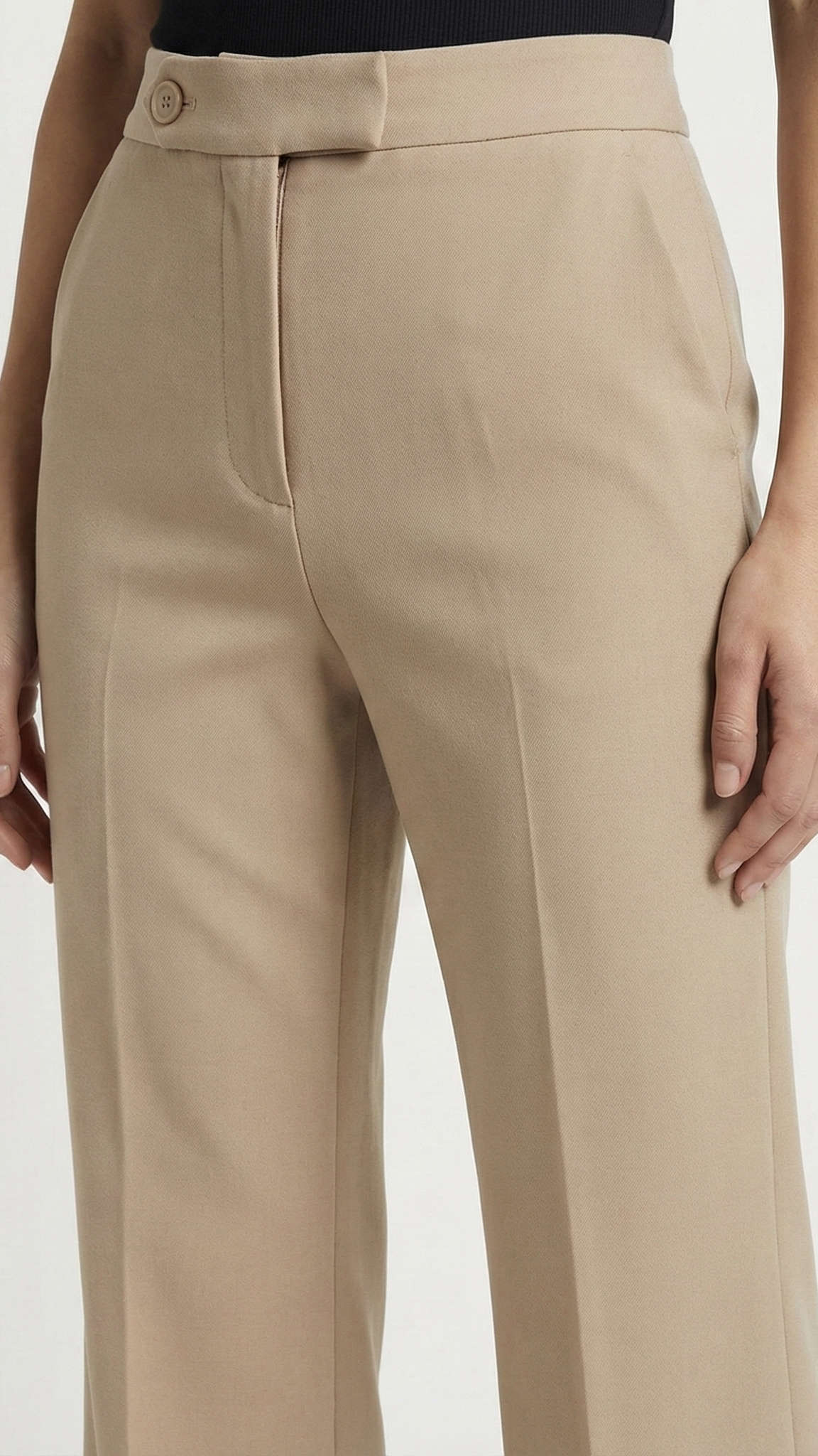 Beige pants worn by a person on a white background