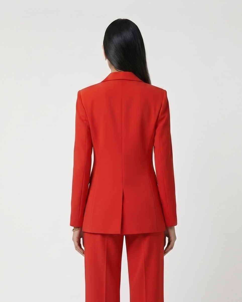 Person wearing a red suit standing against a white background