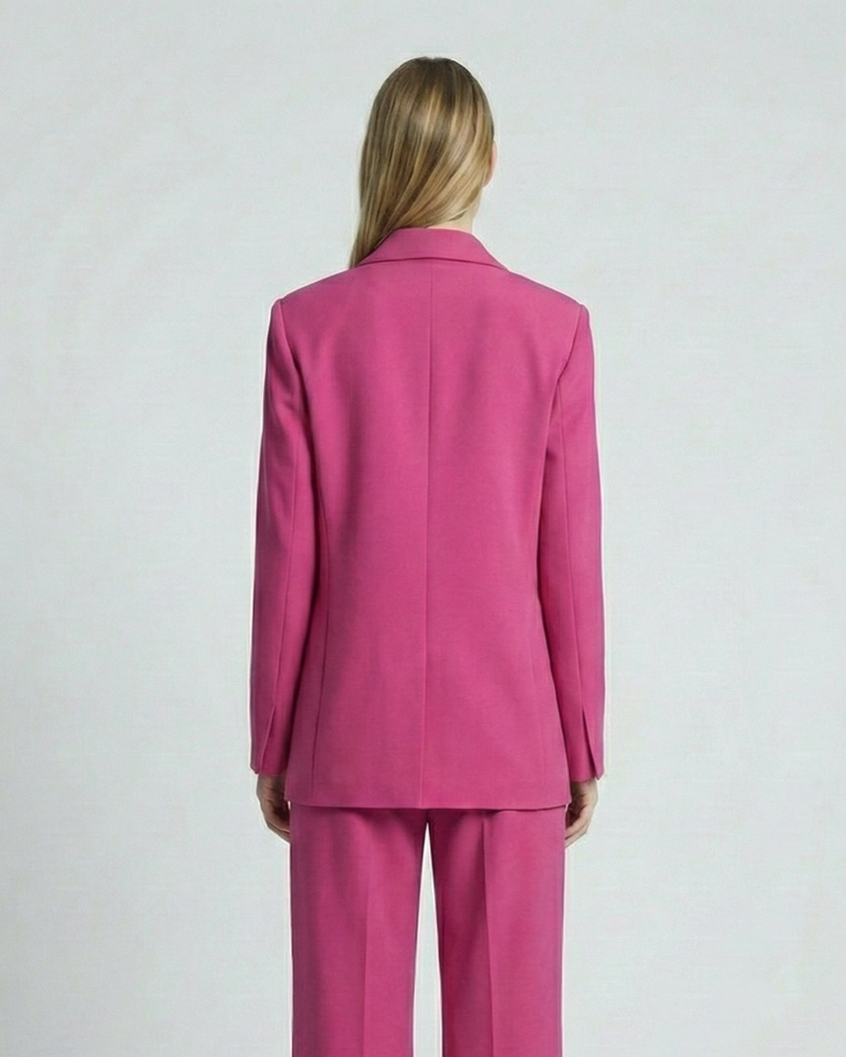Person wearing a pink suit on a white background