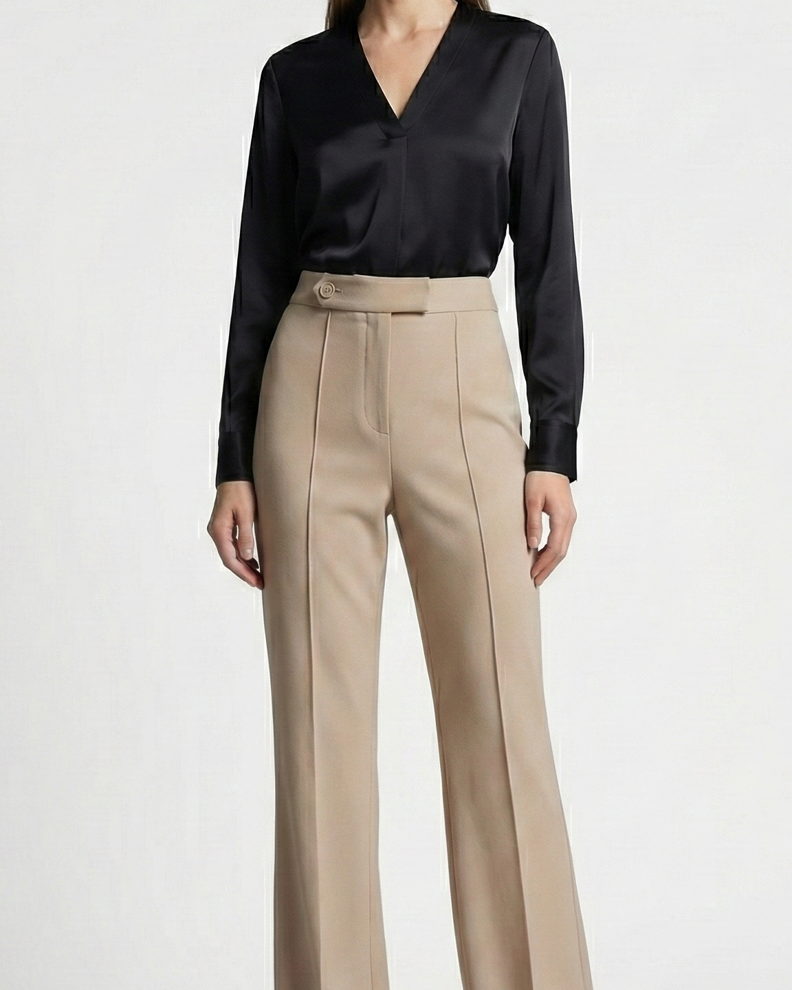 Woman wearing a black blouse and beige pants on a white background