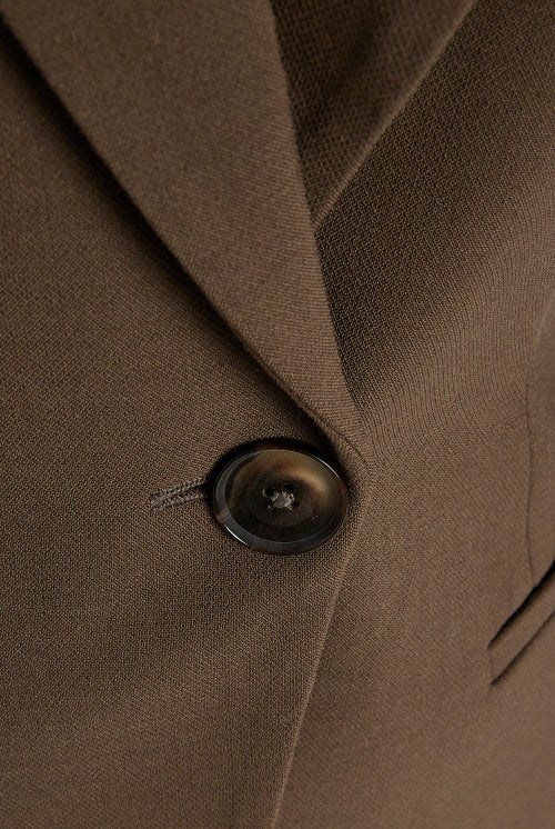 Women's brown fitted blazer with a notched lapel and single closure.