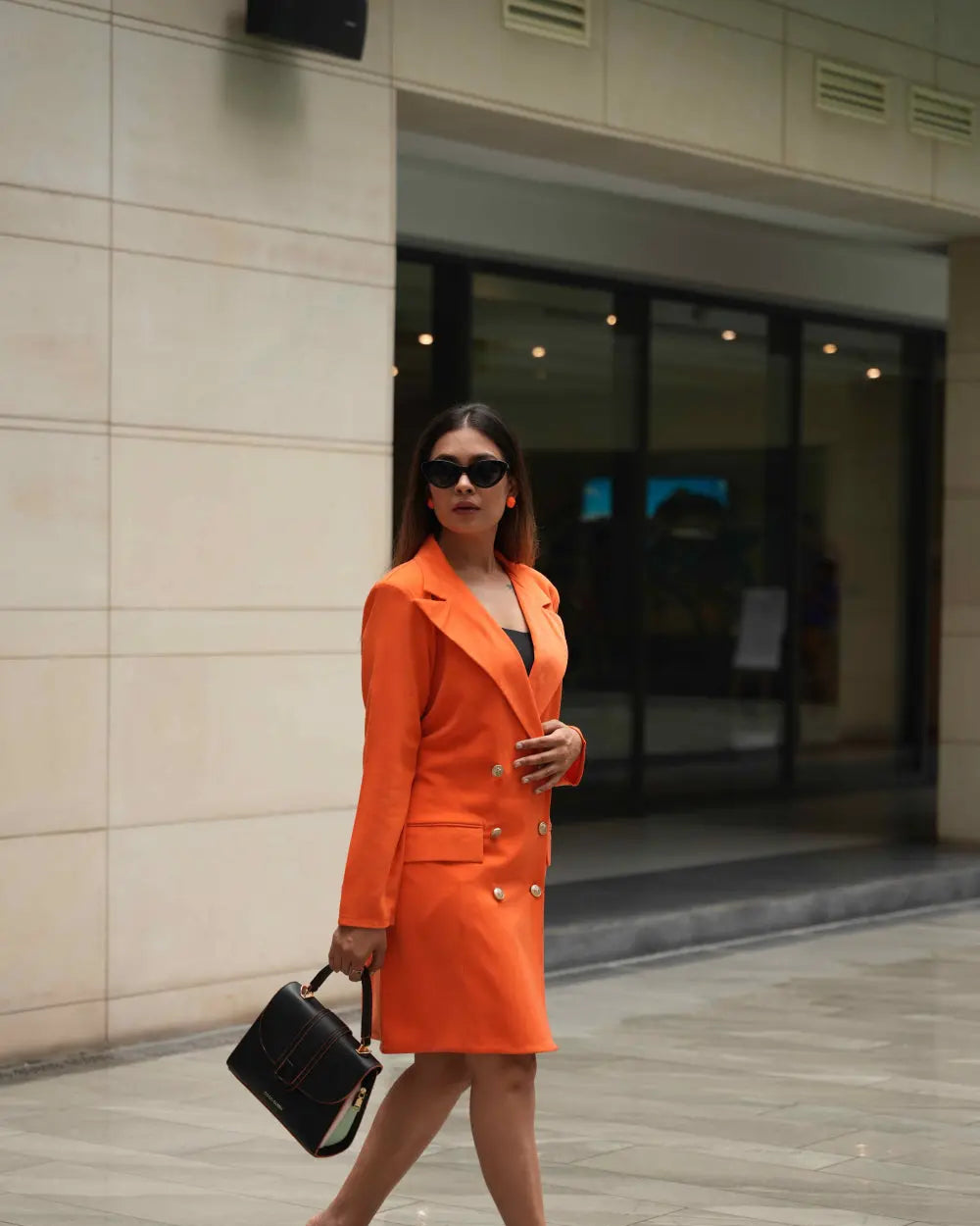 Women's orange blazer dress with front flap pockets for chic styling.