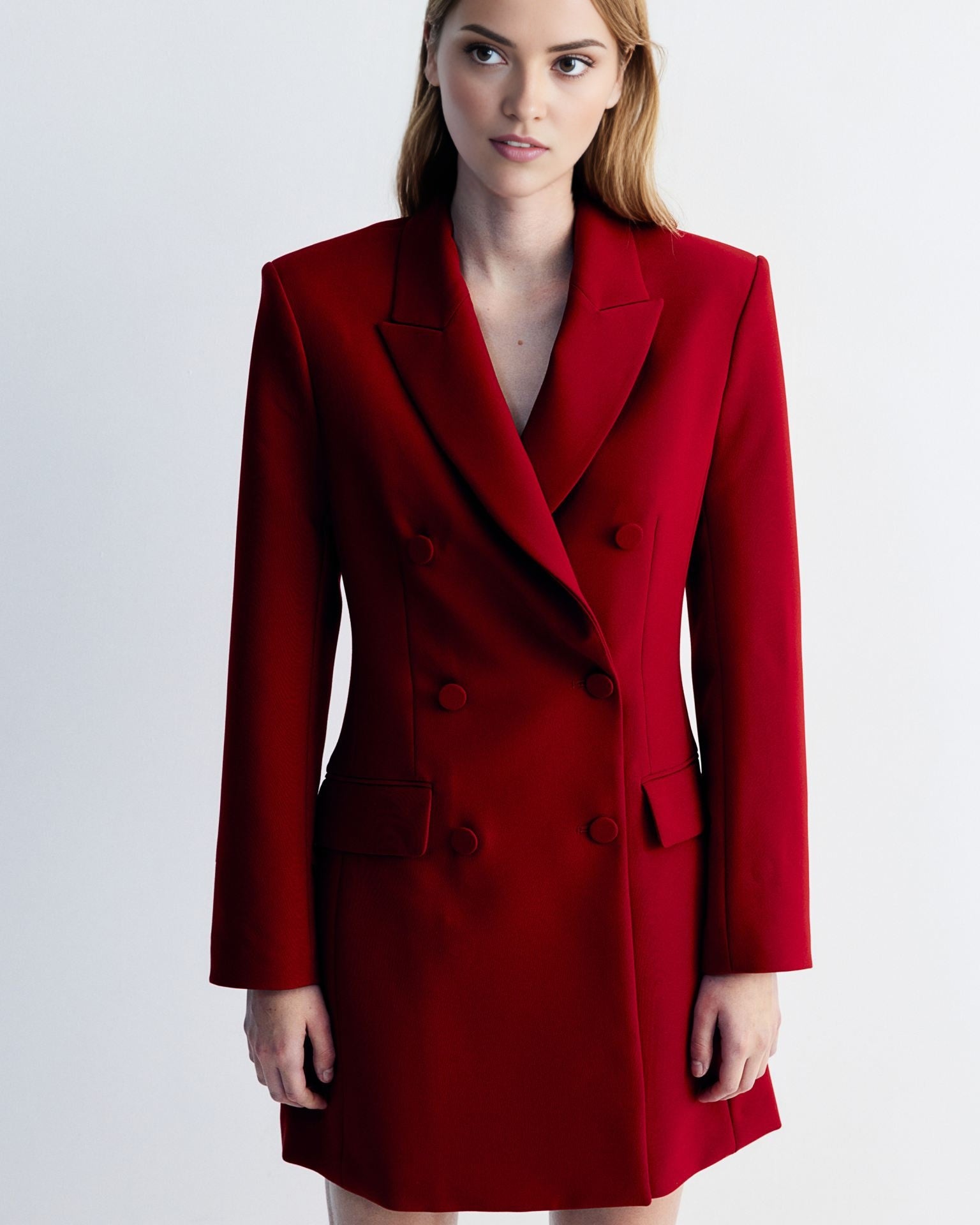 Women's red blazer dress with buttons detailing at waist.