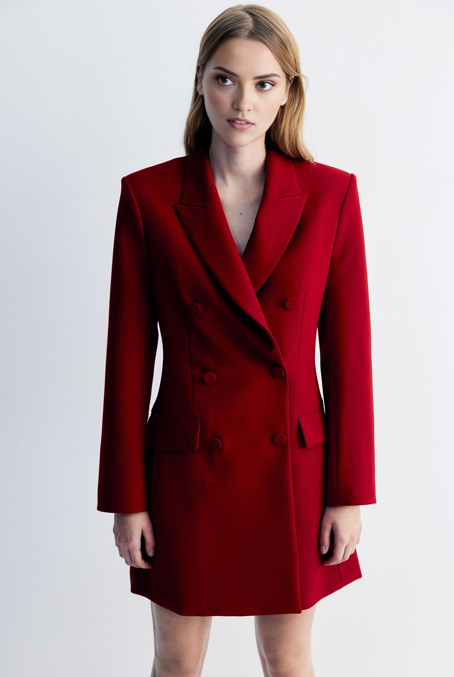 Women's red blazer dress with buttons detailing at waist.