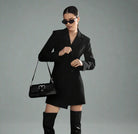 Women's black double-breasted blazer dress with buttons for evening wear.