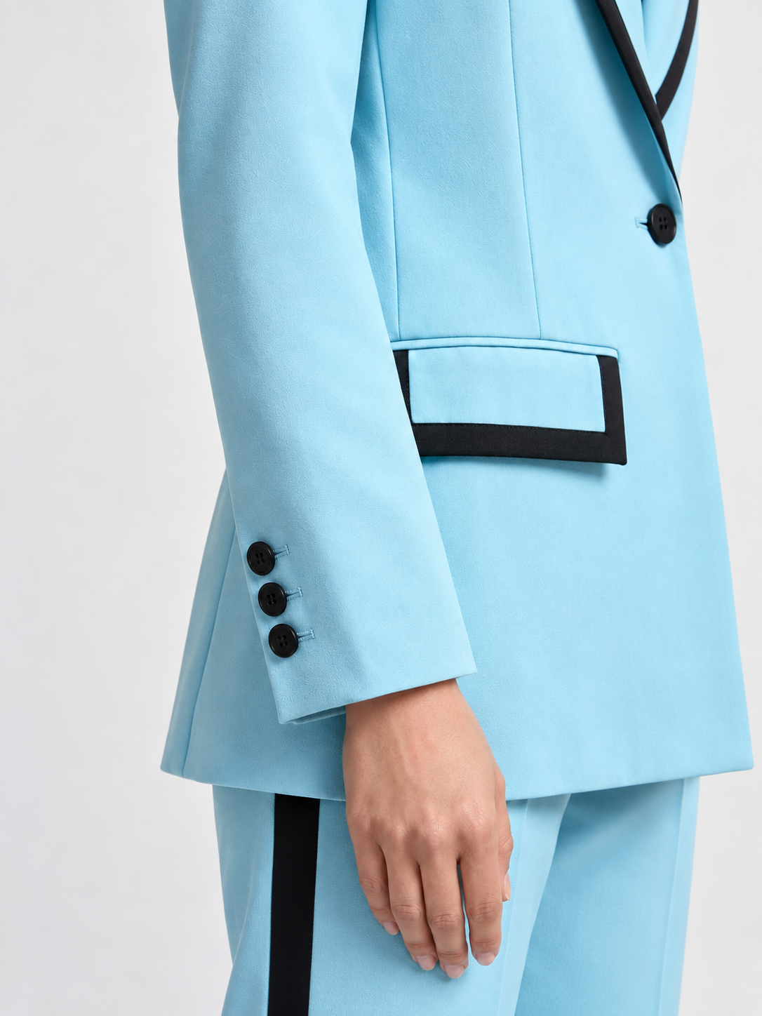 Sky blue blazer close-up showing black-edged flap pocket, black button and three-button cuff | Beyond Formals