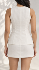 White waistcoat and mini skirt set on model, back view showing centre seam and curved hem | Beyond Formals