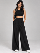 Black wide-leg pleated formal trousers with black crop top on model, full-length front view | Beyond Formals