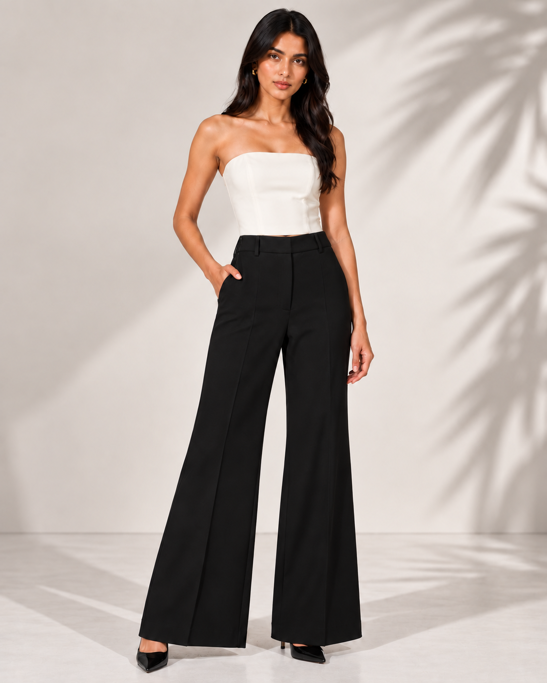 Black high-rise flared trousers with white bustier on model, full-length front view | Beyond Formals