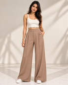 Beige high-waisted wide-leg trousers with cream crop top and white trainers, full-length front view | Beyond Formals