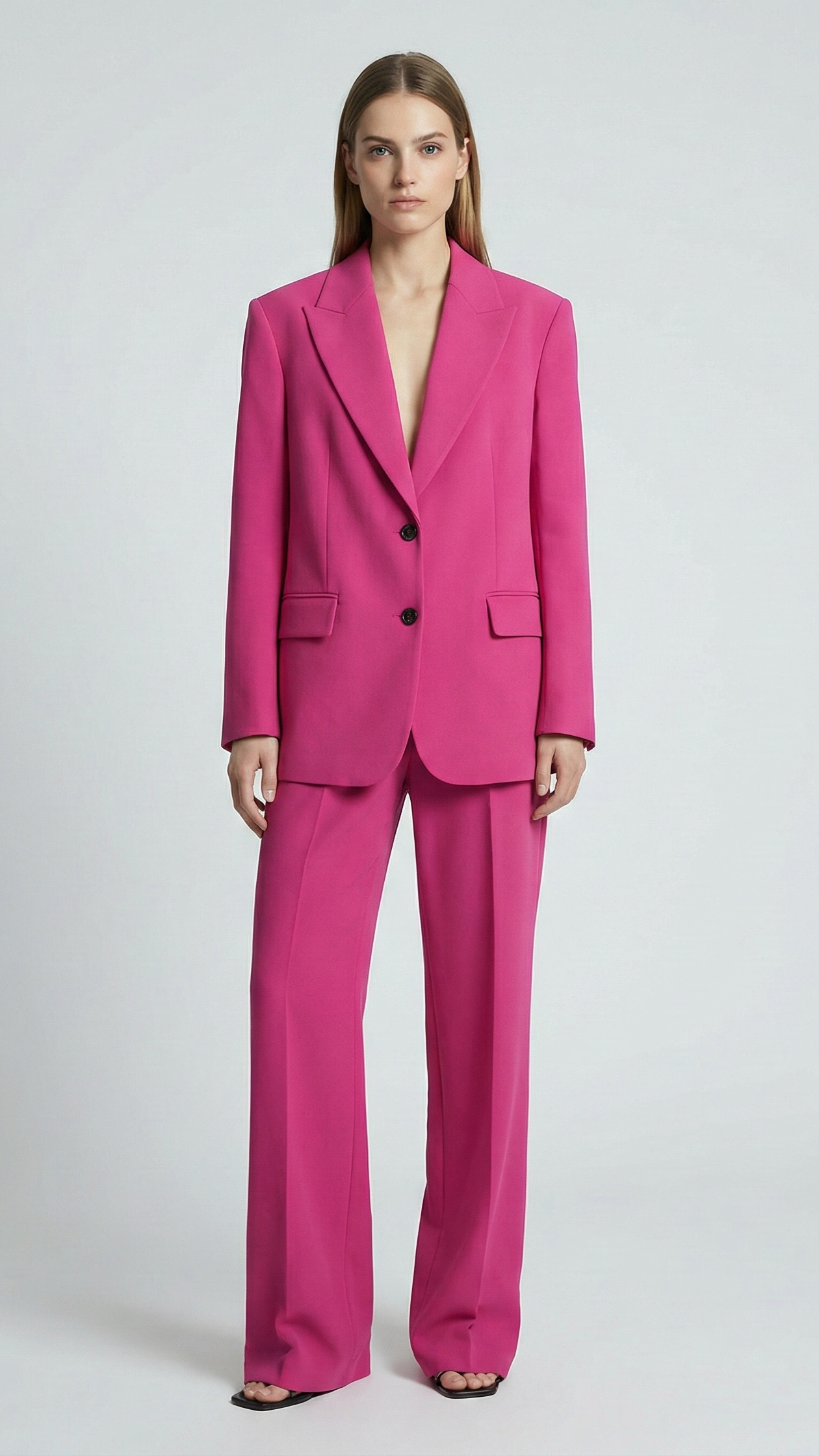 Woman wearing a bright pink suit on a white background