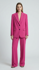 Woman wearing a bright pink suit on a white background
