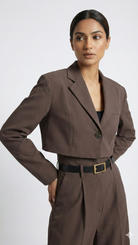 Woman wearing a brown suit with a belt on a white background