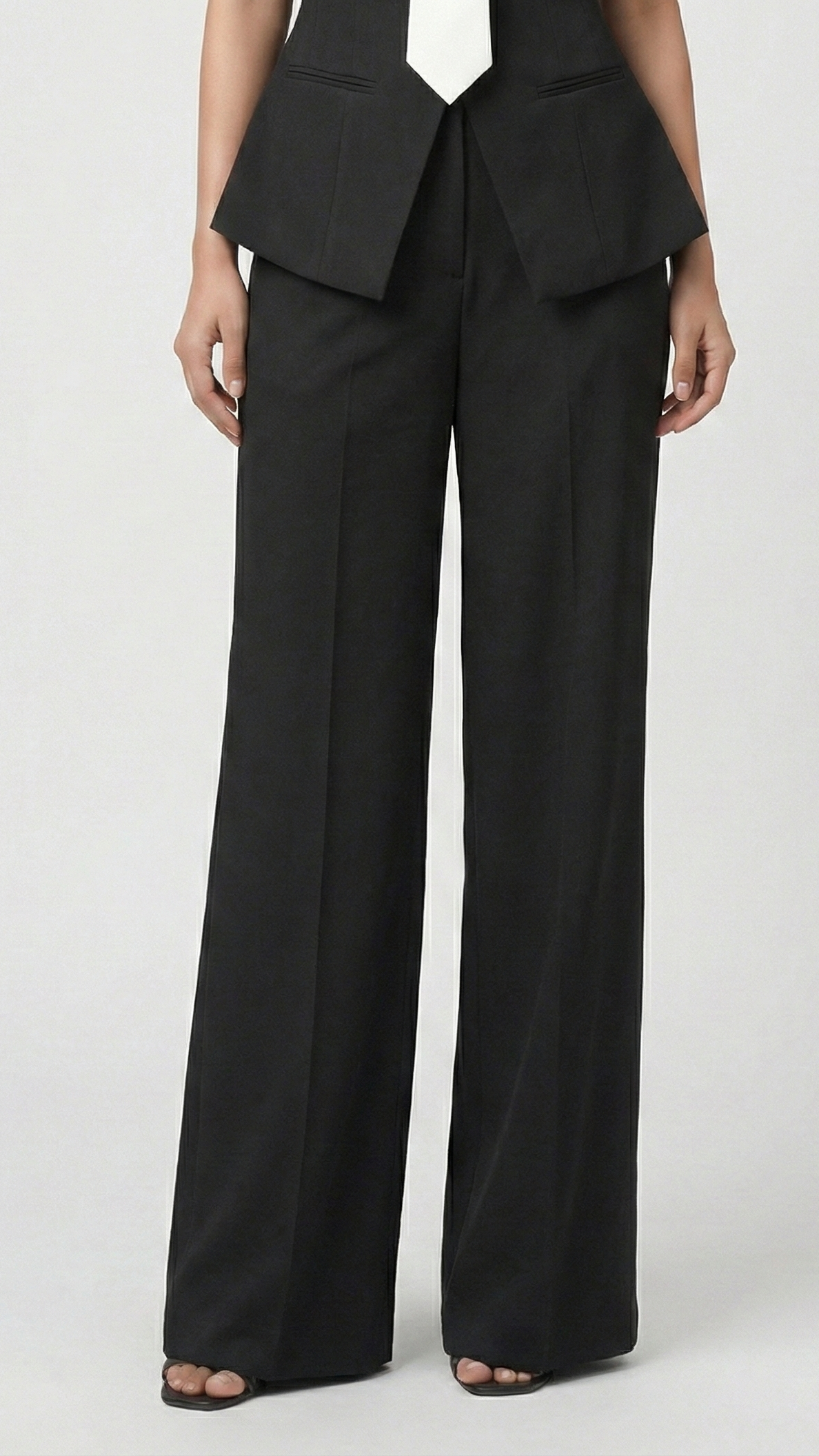 Black suit with a peplum top and wide-leg pants on a white background