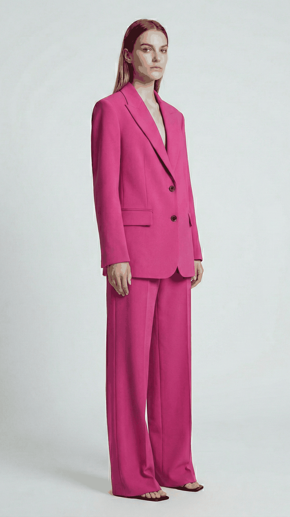 Hot Pink blazer suit set on model, side view showing longline blazer and straight trousers | Beyond Formals