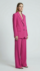 Woman wearing a bright pink suit on a white background