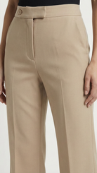 Beige pants worn by a person on a white background