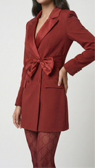 Red blazer with a tie detail worn by a person on a white background