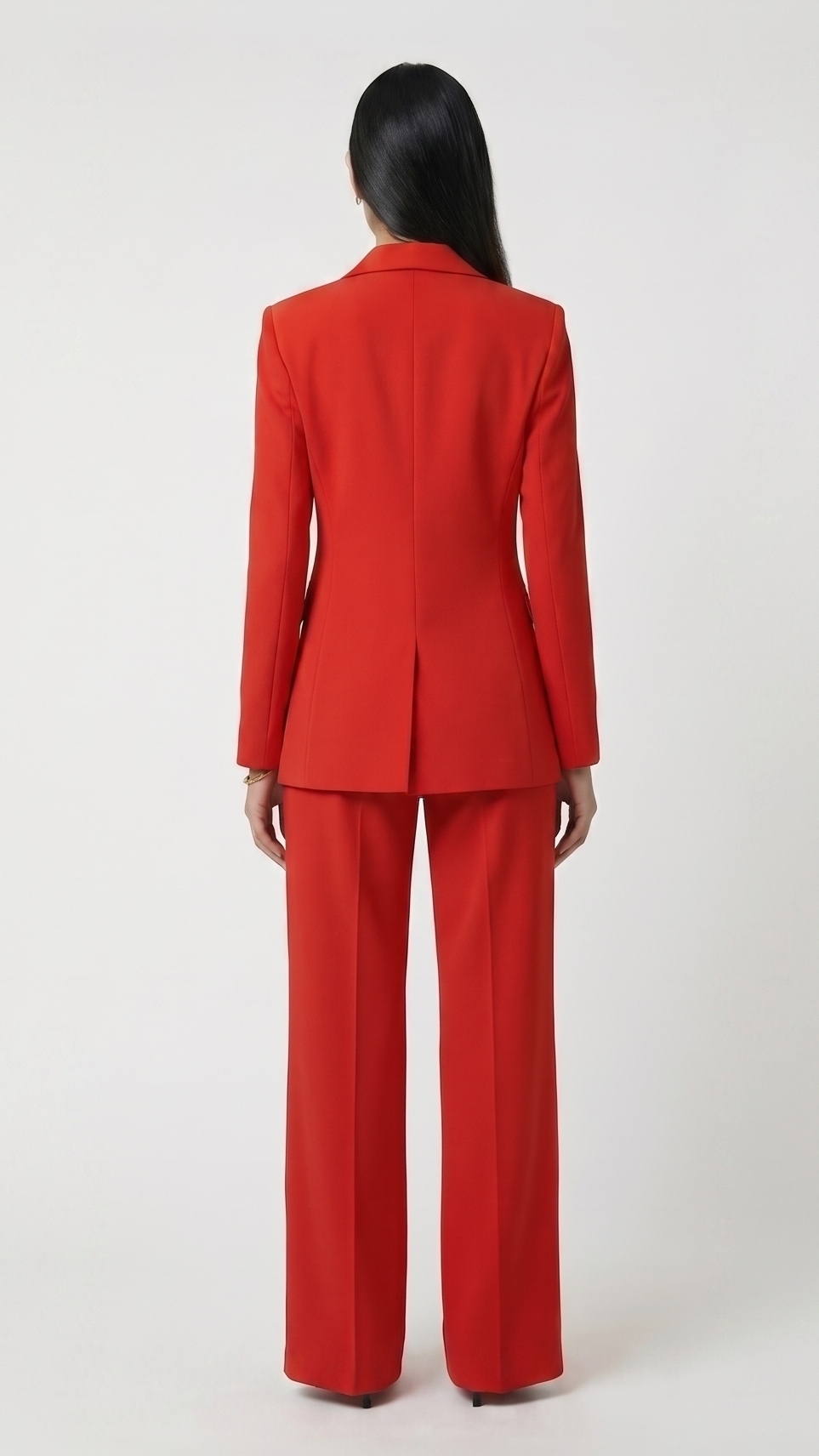 Person wearing a red suit standing against a white background