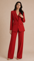 Woman wearing a red suit against a beige background