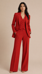 Woman wearing a red suit against a beige background