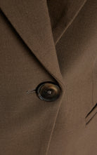 Women's brown fitted blazer with a notched lapel and single closure.