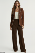 Woman wearing a brown studded blazer and pants on a white background