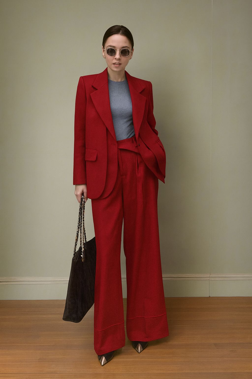 Woman in a red suit standing against a plain background